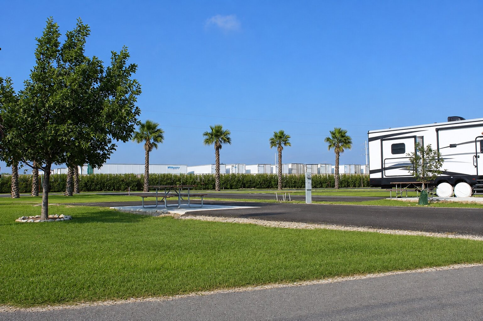 Paved full hookup RV sites lined with trees at Rivercity RV Park